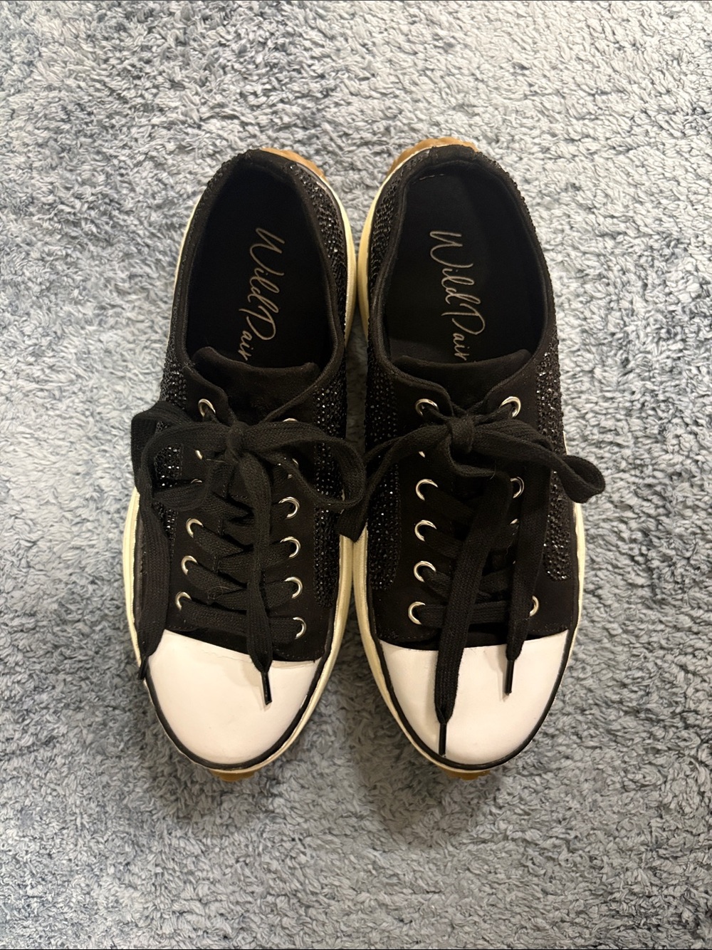 Wild Pair Black Sneakers with White Toe Caps and Subtle Shine